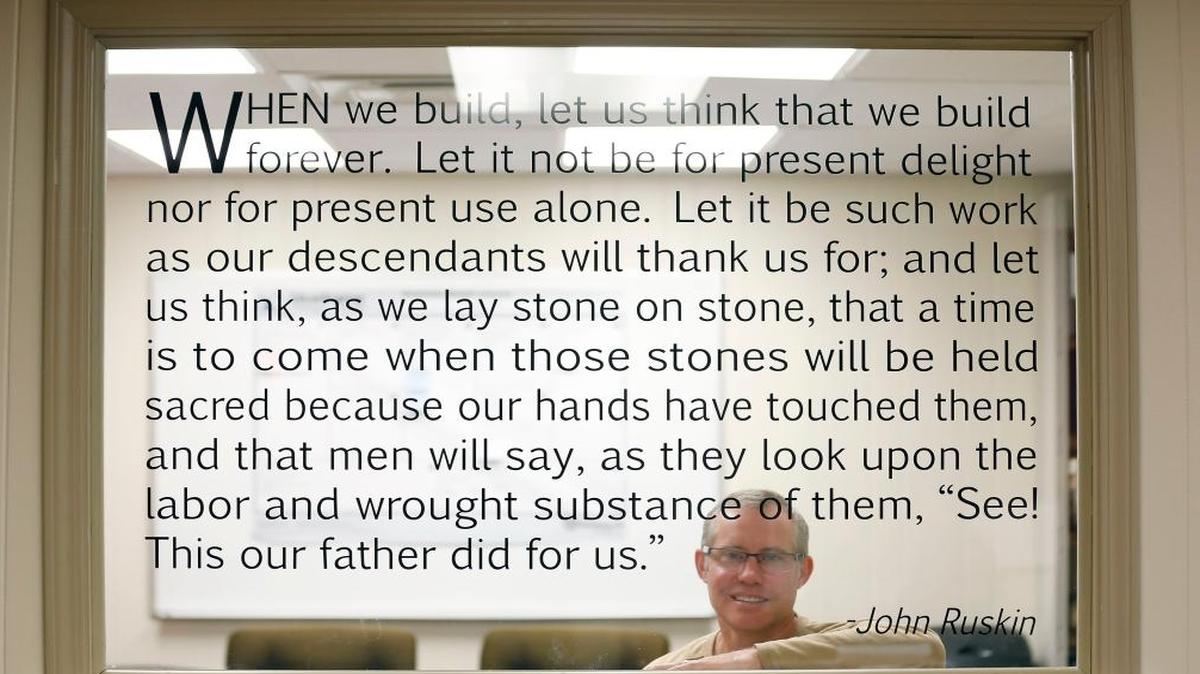 Jace Burris, behind a favorite quote from John Ruskin that is written on a window in his JCBarchitect office, 706 Westland Dr. in Lexington.