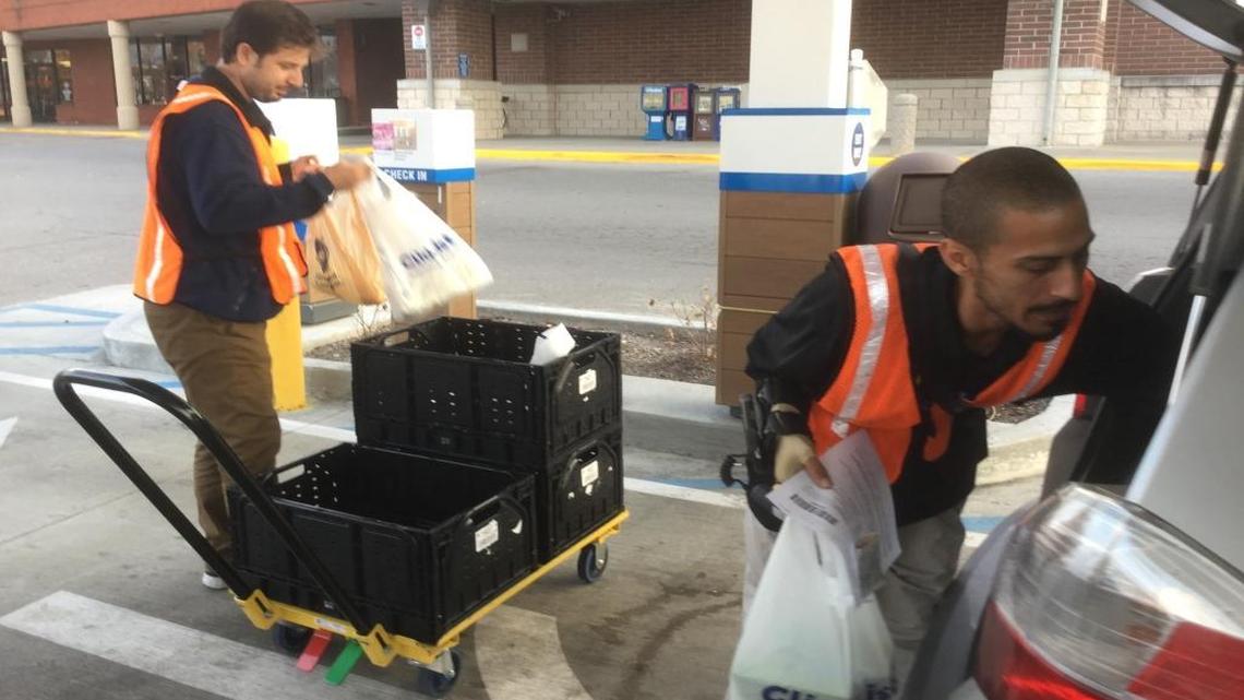 ClickList employees Omid Beitollahi, left, and Jason Rivera, right, loaded my order, placed to test-drive and compare the online grocery ordering services of Kroger and Walmart.