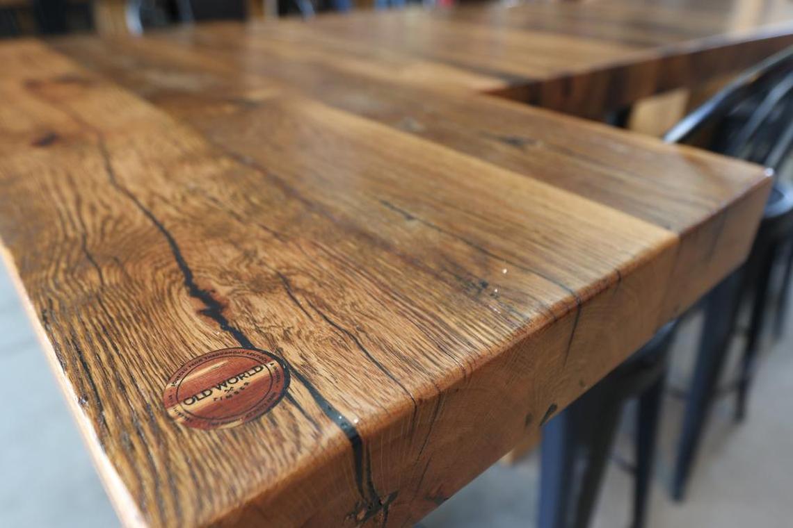 An Old World Timber stamp found on their large horseshoe-shaped table made of reclaimed wood within The Barn in Summit at Fritz Farm.
