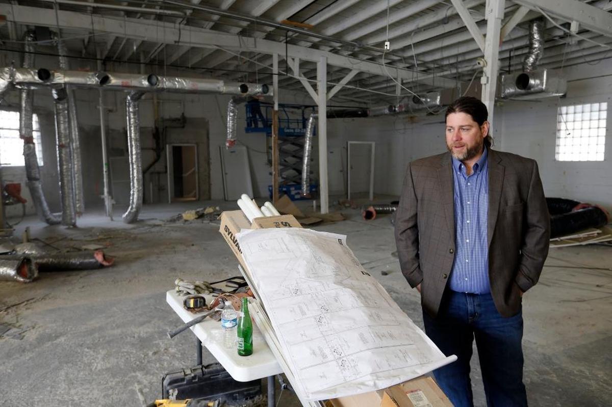 Chad Walker with the plans for 740 National Avenue, undergoing renovation in April. The building is almost entirely leased, except for one spot, and all of the new businesses are also owned by women.