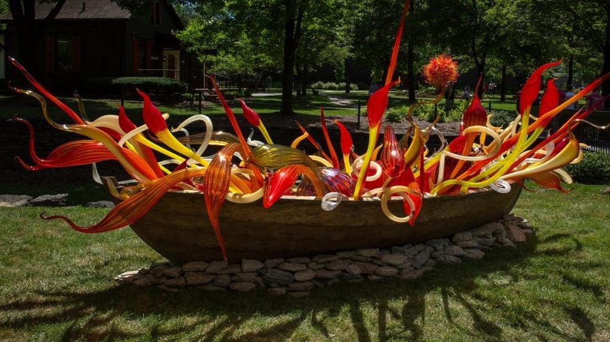 Dale Chihuly’s Crimson and Chestnut Fiori Boat features an array of whimsical, nature-inspired shapes in an 18-foot wooden boat.