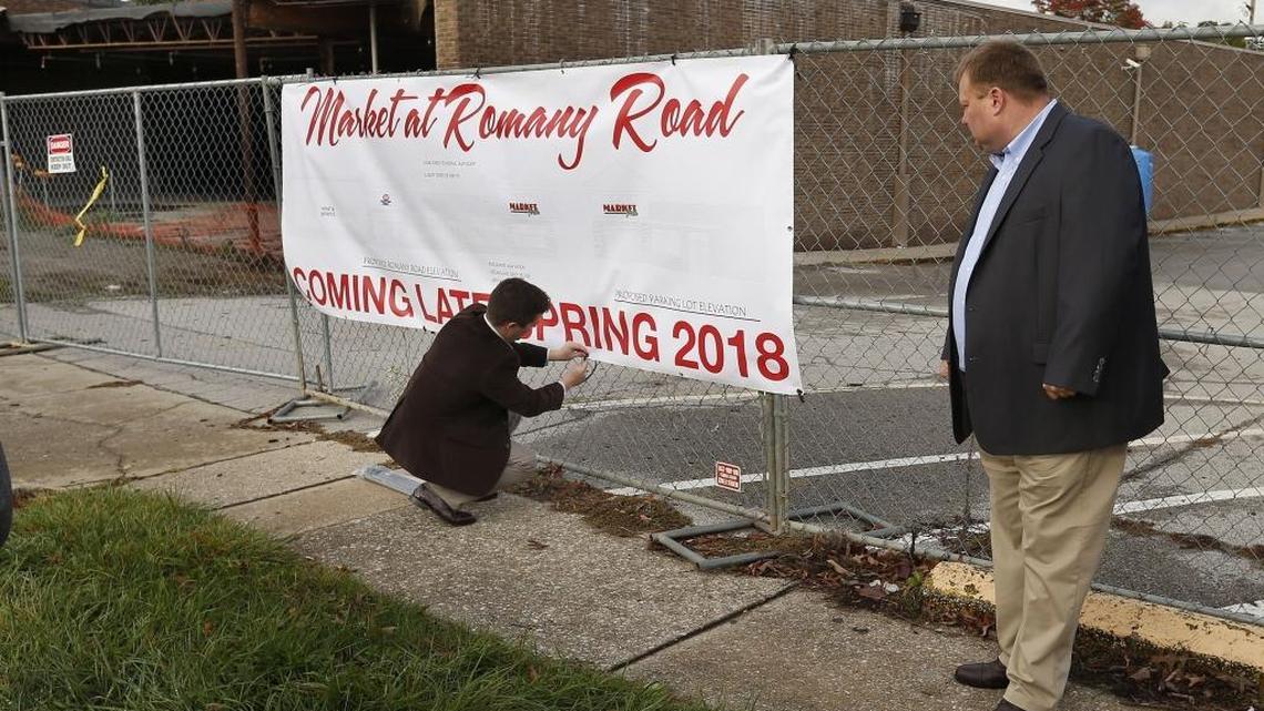 Jake Jennings of Laurel Foods attached a banner announcing the coming of the Market at Romany Road as Martin Cox, owner of Cox Foods, right, looked on. Cox owns 11 other IGA stores in southeastern Kentucky.