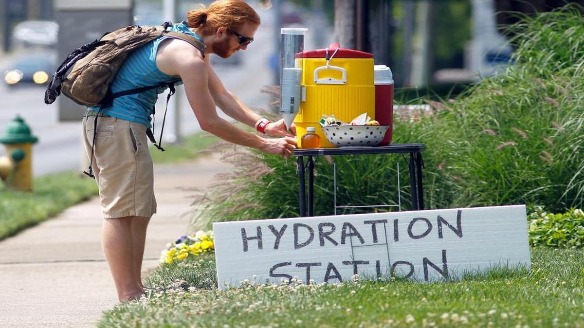 Aaron Elswick stopped for a cup of water in 2012 at Debra Hensley’s hydration station in front of her State Farm Insurance Agency in Lexington.