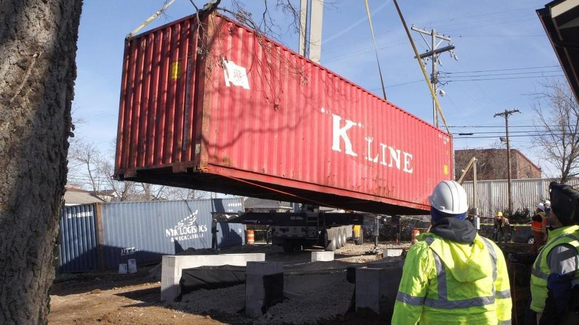 A shipping container was lowered by crane onto a foundation on York Street in Lexington Wednesday as part of the LuigART Makers project, which will provide live-work spaces that resemble the area's historic shotgun houses.