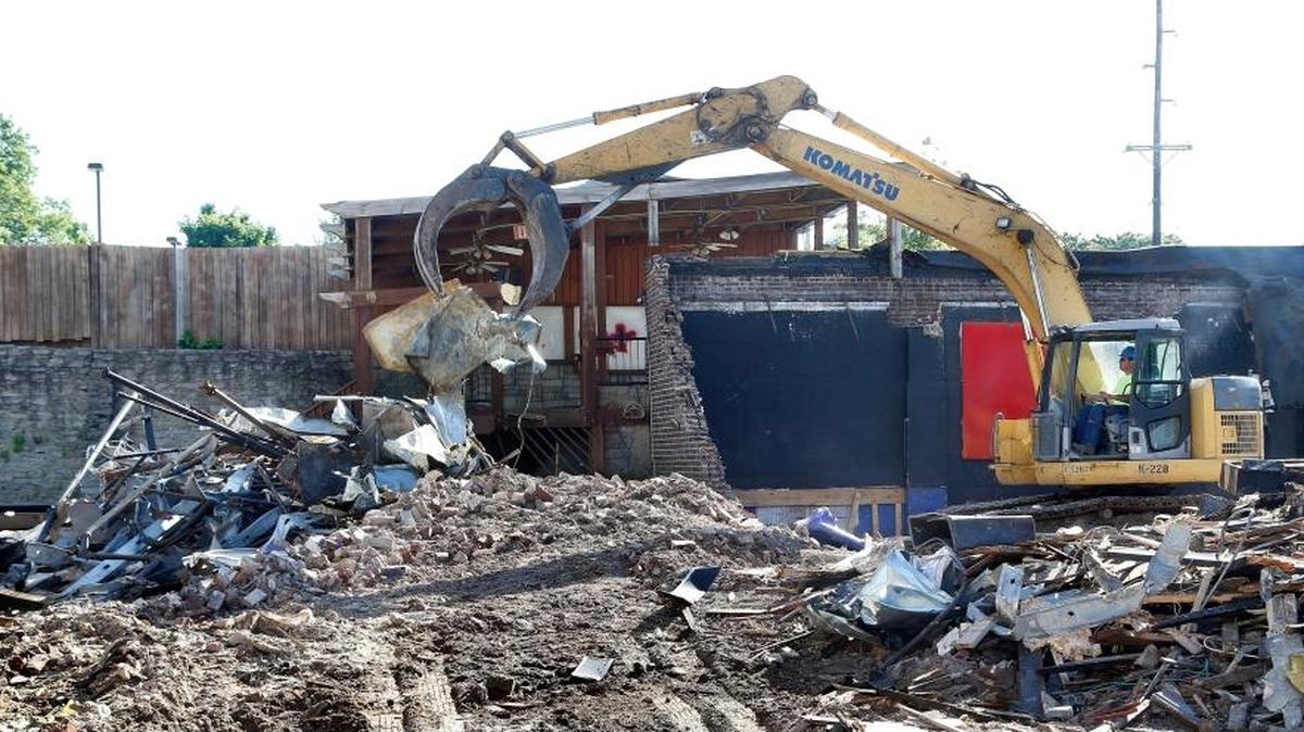 Excavator operator P.C. Campbell, with Superior Demolition, tok down the former A1A Sandbar on East Main Street on Monday near Eastern Avenue in downtown Lexington. The demolition began last week. The former A1A Sandbar was sold for $1.2 million to a developer who plans to build a five-story mixed-use complex to be called Field & Main. Developer Jeff Morgan wants to have a business on the ground floor, condominiums on the upper four floors and a two-story, 52-space parking garage.