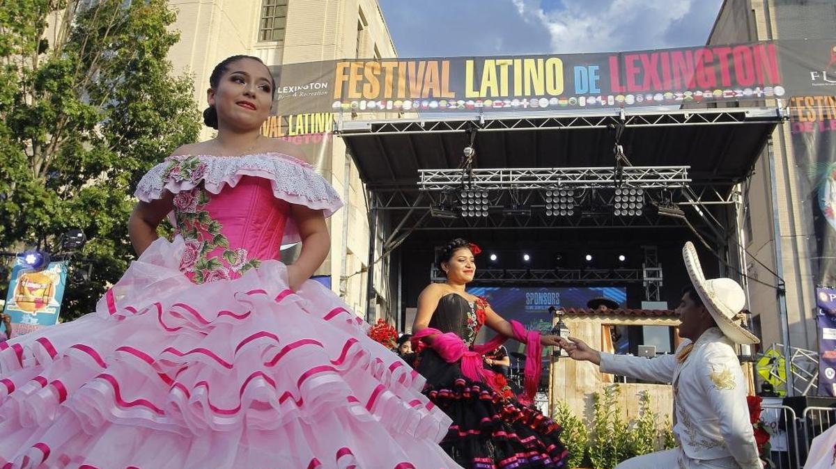 A dancer looks on as Pamela Hernandez and Francisco Espinosa of Arte Latino perform the Quinceanera dance at Festival Latino de Lexington. Saturday’s festivities were in front of the Robert F. Stephens Courthouse Plaza.