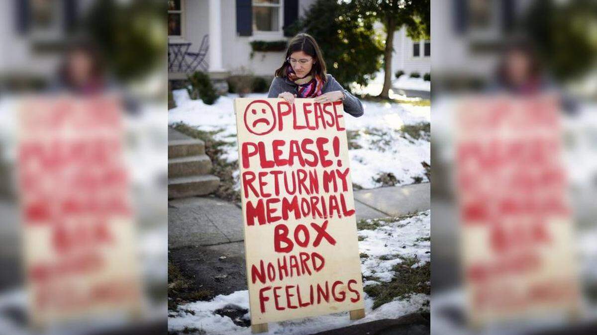 Nicole Breazeale stood by the sign in her front yard that appeals for the return of a memorial of books and bumper stickers made for her late husband Phillip. A neighbor painted the sign.