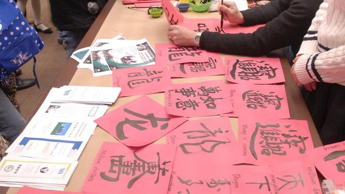 Visitors painted Chinese calligraphy at the University of Kentucky Confucius Institute table during the Chinese New Year Celebration at the UK Singeltary Center in 2012.