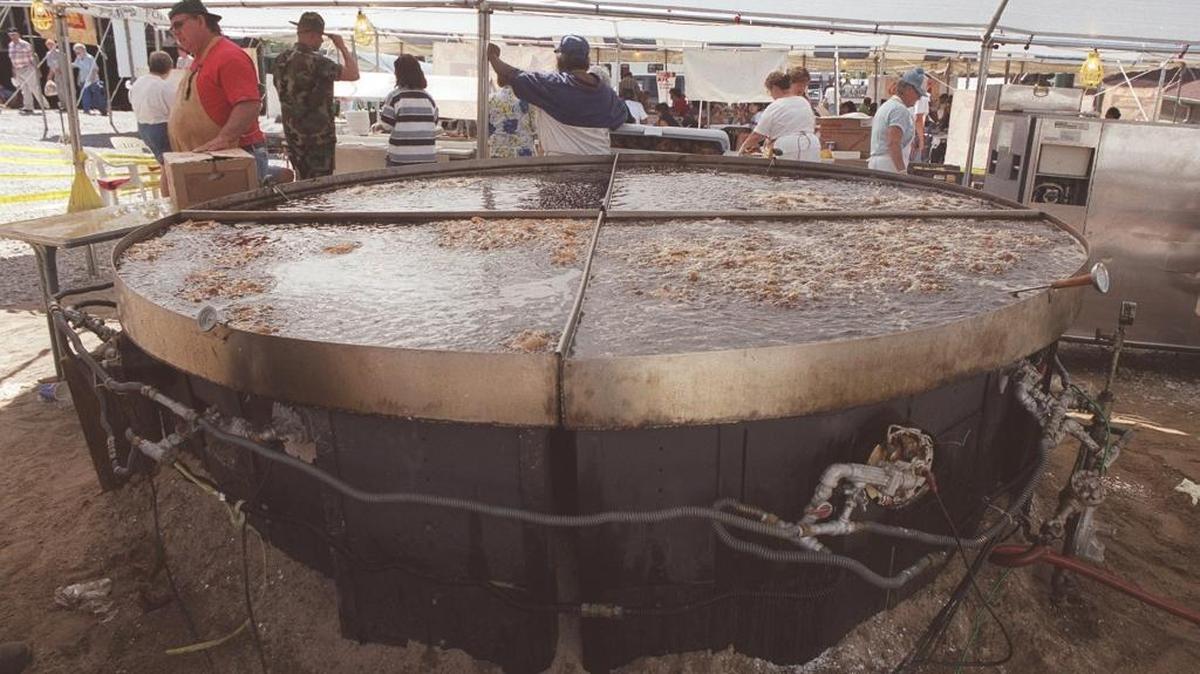In 1999, a new world's largest skillet was constucted for London's World Chicken Festival. It is 10 feet, 6 inches in diameter, 8 inches deep and weighs 700 pounds. It requires 300 gallons of cooking oil to fill. Can cook 600 quarters of chicken at one time.