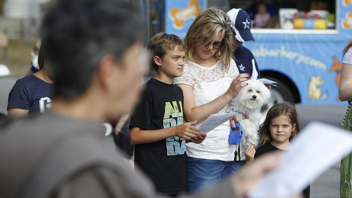 Cherie Flueck holds Comet as she stands with children Tristan, 12, and Ashton as Nan Plummer leads the group in prayer during the Blessing of the Animals outside the Good Shepherd Episcopal Church in Lexington, Ky., Sunday, October 16, 2016.