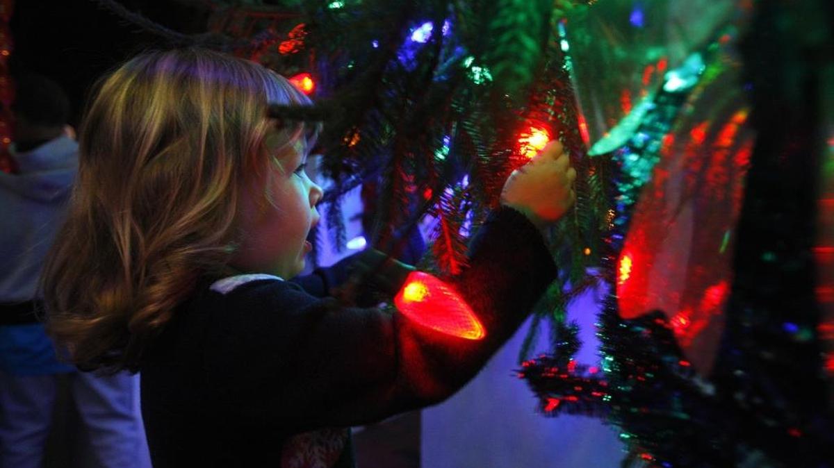 Lilly Bricken touched a light on the city Christmas tree during Luminate Lexington at Triangle Park in Lexington on Friday, Nov. 27, 2015.