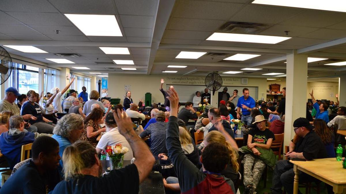 More than a dozen people at the Catholic Action Center raised their hands Sunday, when asked whether they had been approached to cash a counterfeit check.