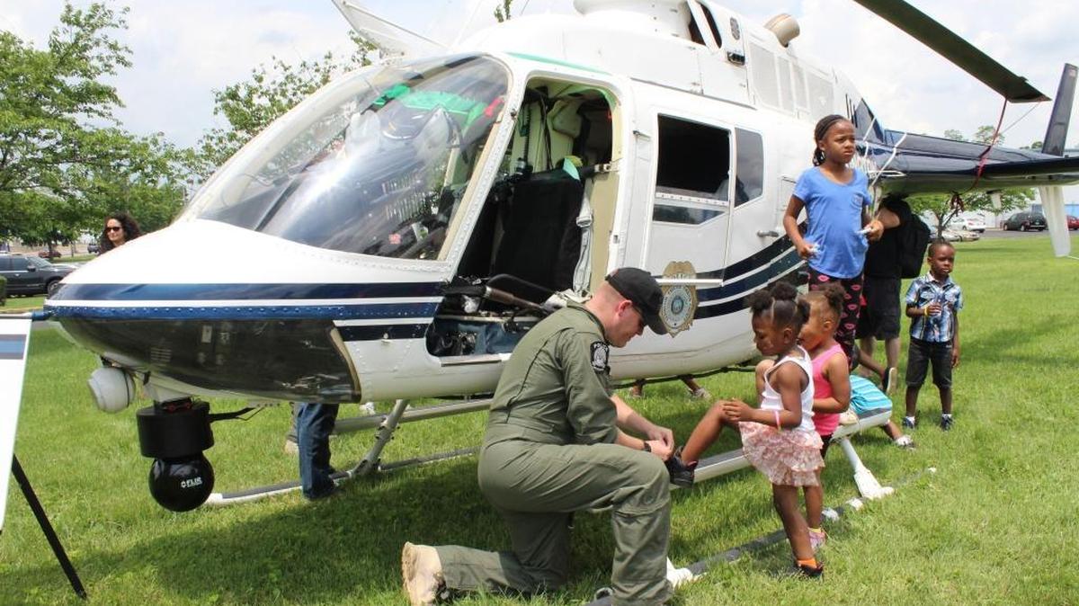 Officer Ryan Holland, a tactical flight officer and neighborhood resource officer for the Lexington police, tied a girl’s shoe at Picnic with the Police Saturday at Douglass Park.