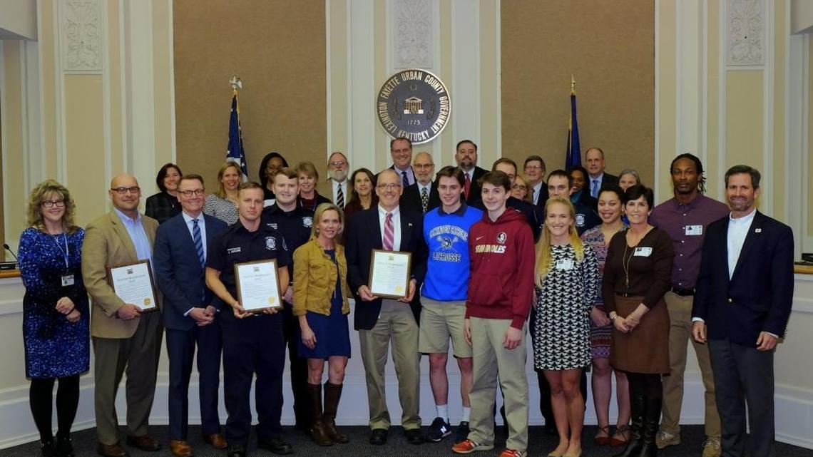 City of Lexington lawyer Dave Barberie (center, blue blazer) is honored with Lexington paramedics, High Street YMCA staff and Dr. Allison Stewart, (second from right, front) and Dr. Karen Wolfsdorf, (far right) at Thursday night’s council meeting.