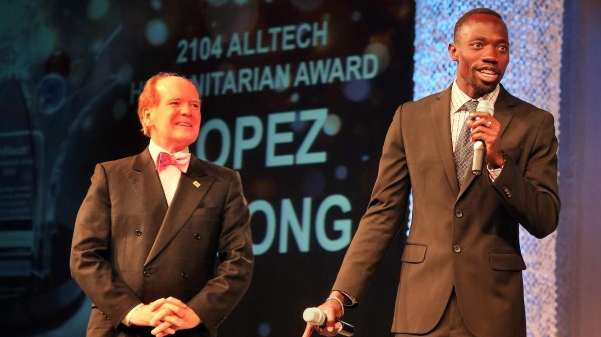 At Alltech’s annual global conference in Lexington in May 2014, Pearse Lyons presented a humanitarian award to Lopez Lomong, right. Lomong told of being kidnapped by soldiers in his native Sudan at age 6, escaping and after 10 years in a Kenyan refugee camp coming to America where he became a two-time Olympic runner and carried the U.S. flag at the 2008 Beijing Games.