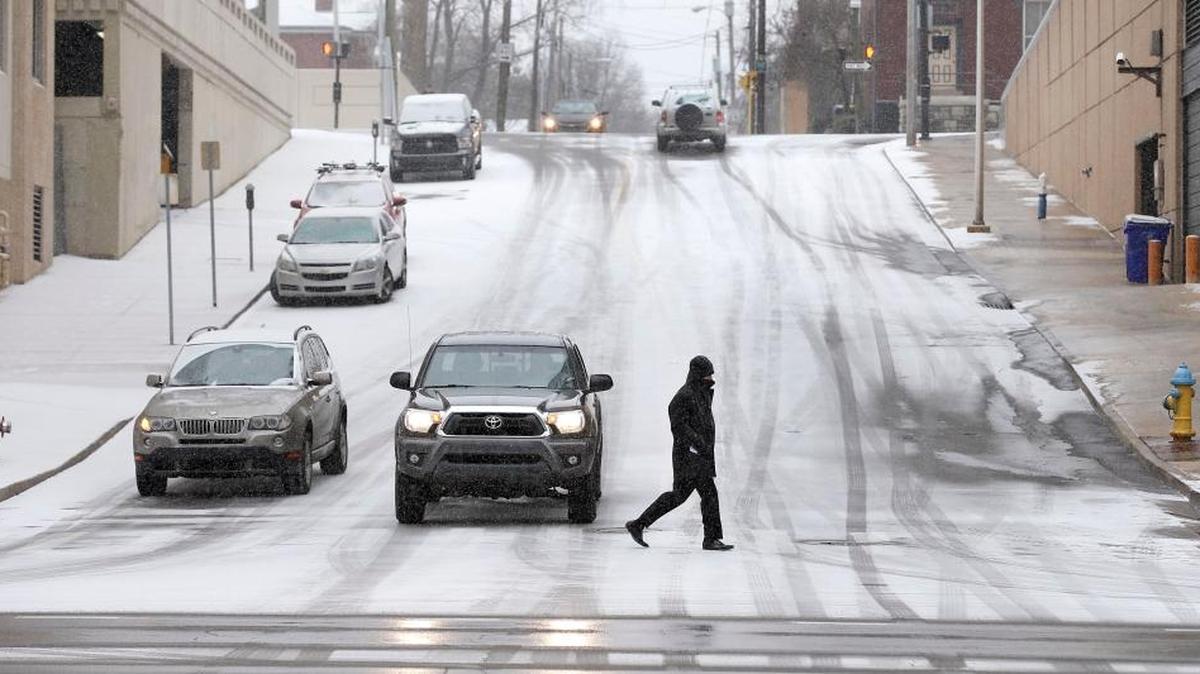 A man crossed South Mill St. on West Vine St. soon after the snow started in Lexington, Ky., Thursday, January 5, 2017. Lexington is projected to receive its first snow of the season on Saturday.