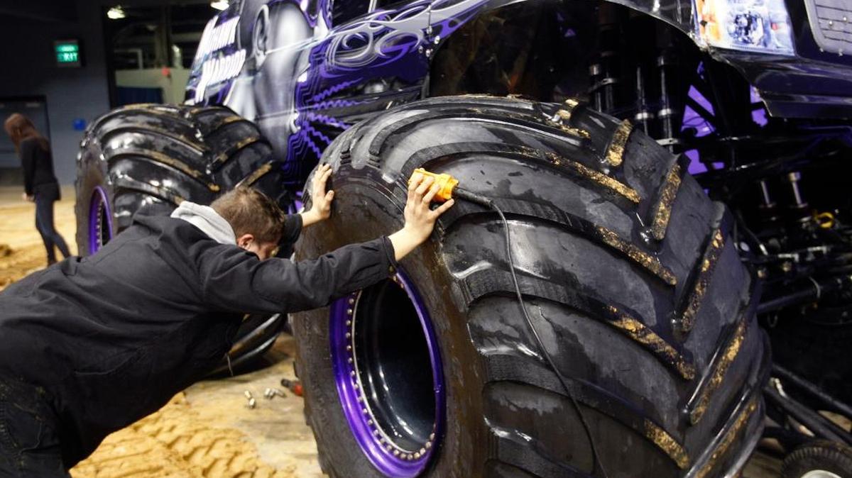 Crew chief Christian Norman places a 750-pound tire on the Mohawk Warrior in advance of last year’s Monster Jam at Rupp Arena. This year’s event takes place Saturday.
