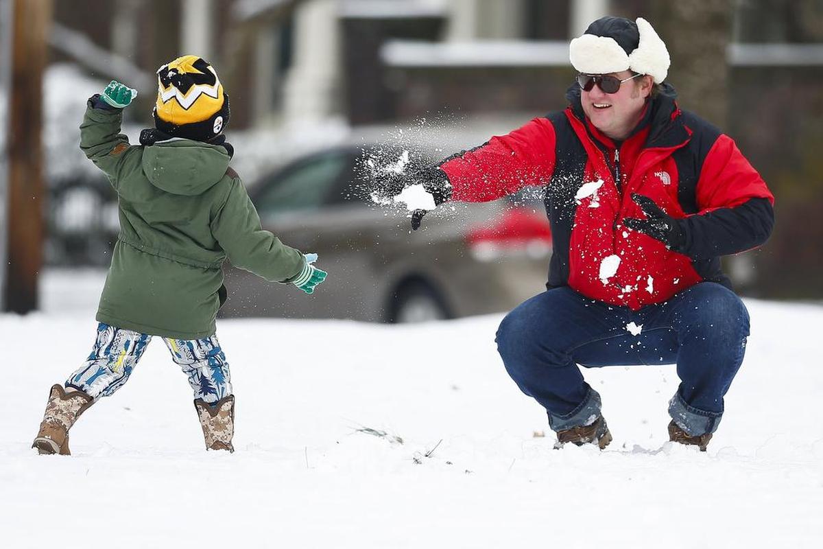 Darren Taylor, of Lexington, had a snowball fight with his sons Carter Taylor, 5, left, and Wesley Taylor, 5, not pictured, at Gratz Park Saturday in Lexington. An estimated two inches of snow blanketed the area Saturday morning.