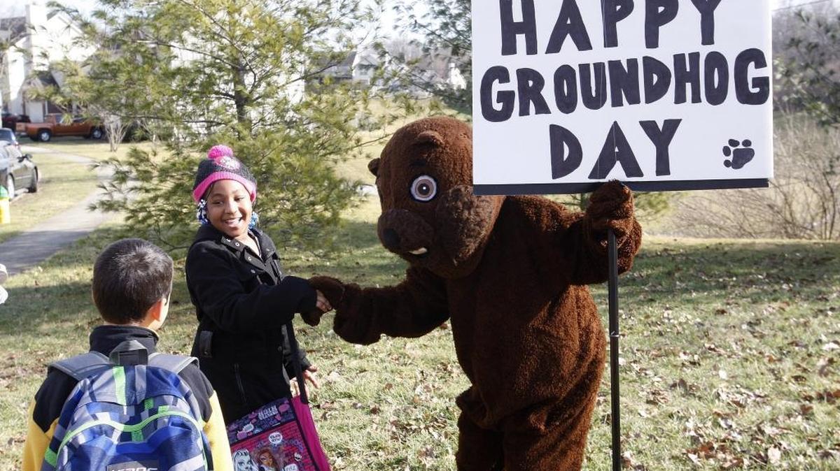 Amya Linton, 9, and Uzziel Batres visited with Stacey Underhill who donned a groundhog costume and spread some love on Groundhog Day by waving to passersby and giving Groundhog Day stickers to children on Old Paris Pike at the entrance of Old Paris Place subdivision on Tuesday.