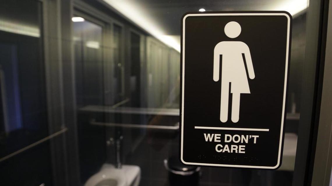 In this photo taken Thursday, May 12, 2016, signage is seen outside a restroom at the 21c Museum Hotel in Durham, N.C. North Carolina is in a legal battle over a state law that requires transgender people to use the public restroom matching the sex on their birth certificate. The ADA-compliant bathroom signs were designed by artist Peregrine Honig.