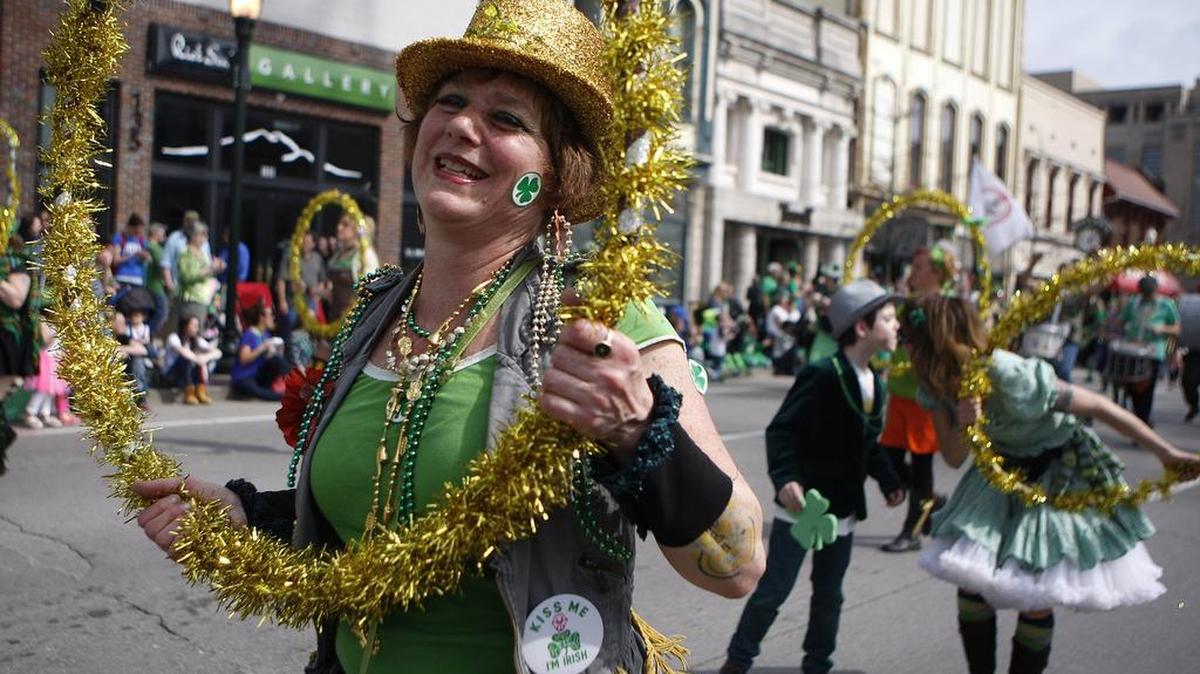 A member of the March Madness Marching Band wears a “Kiss Me I’m Irish” button as others kiss in the background during the St. Patrick’s Day parade in Lexington, Ky., Saturday, March 12, 2016.