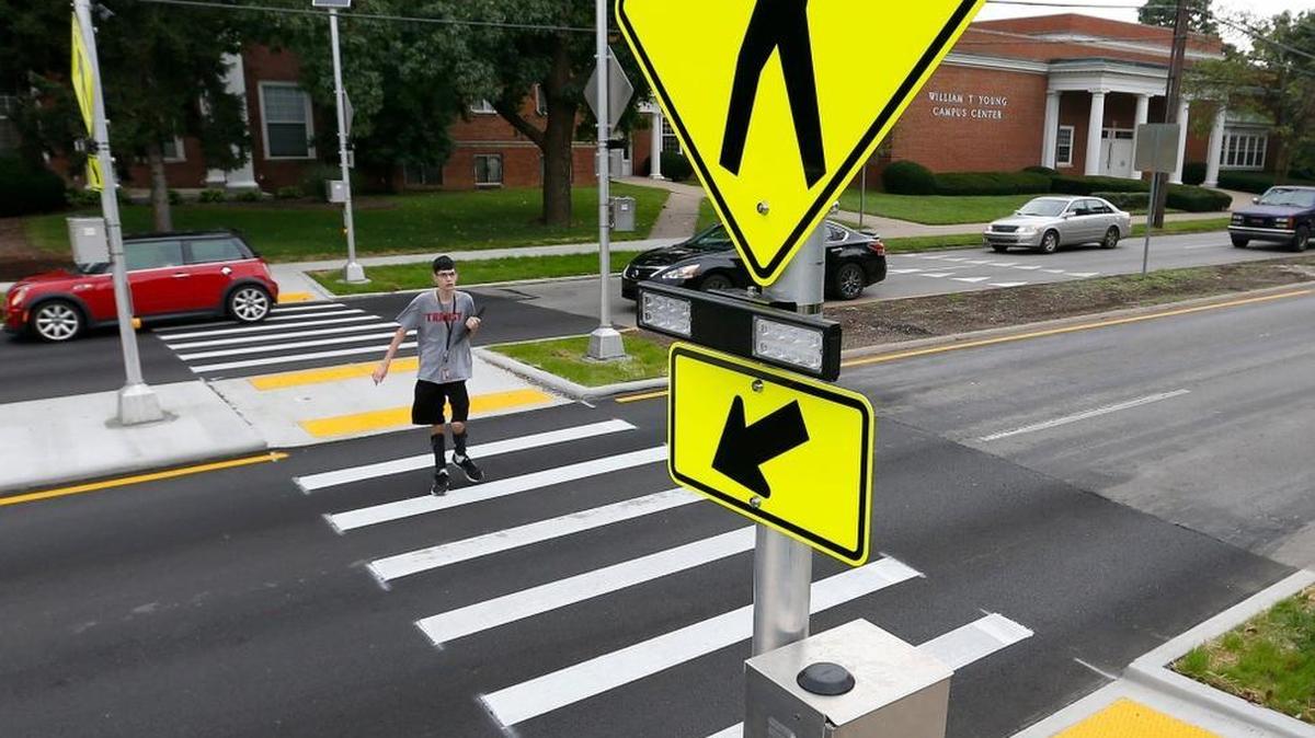 Nathan French, a Transylvania University sophomore from Louisville, crossed North Broadway near Fourth Street in a campus’ redesigned crosswalk Monday. The crosswalk connects the main campus to the residential areas.