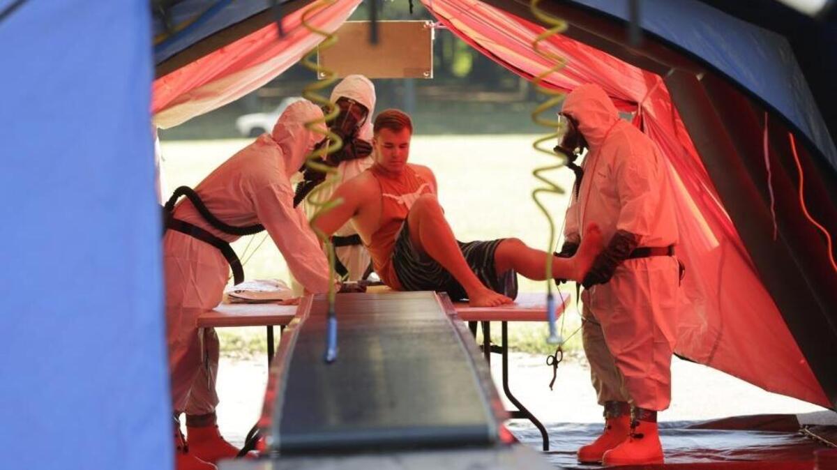 Paramedics in full chemical protective suits and gas masks helped mock victim Wes Catron during a disaster exercise at Jacobson Park in Lexington. The exercise was part of a 10-county simulation of an accident involving chemical agents stored at the Blue Grass Army Depot in Madison County. Students from Eastside Technical Center were the volunteer victims for Lexington’s first responders.
