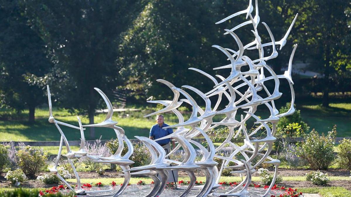 Fayette County Coroner Gary Ginn placed a rose for each victim at the 5191 memorial sculpture before the memorial service marking the 10th anniversary of the crash of Comair Flight 5191 held at the Arboretum in 2016.