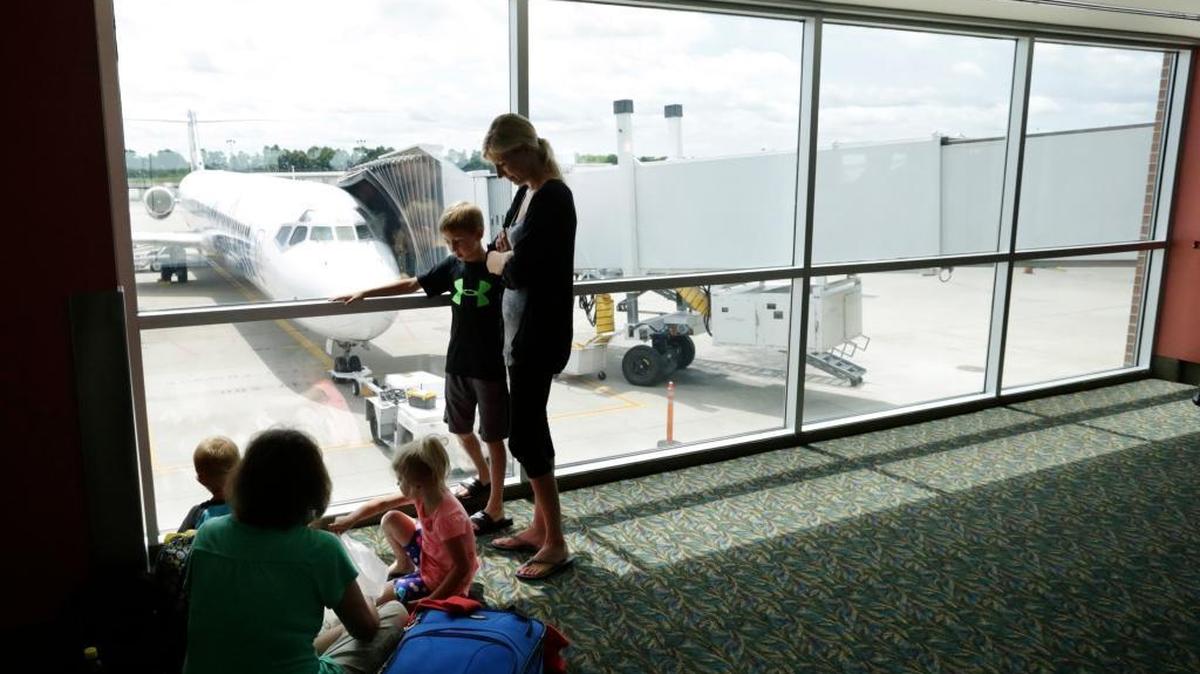 In this June 2014 file photo, Teresa Donovan and grandson Liam Gilbert, 4, seated at left waited for a flight with new friends Allisha Daraswad, her son Thai Daraswad, age 7, and Lynnley Daraswad, age 3, (seated in center) at Blue Grass Airport in Lexington.