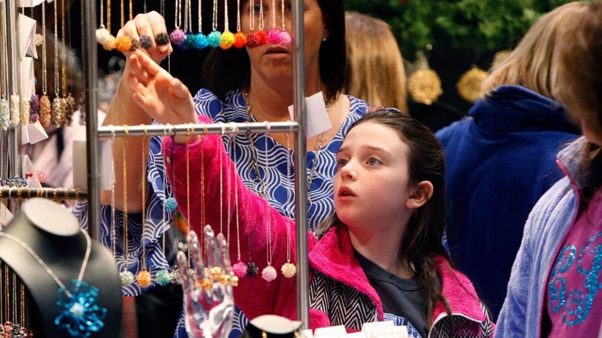 Jill Price of Flemingsburg looks on as daughter Sadie Price, 9, selects a necklace to purchase from exhibitor Village Designs at Kentucky Crafted: The Market at Lexington Center in Lexington March 7, 2015.