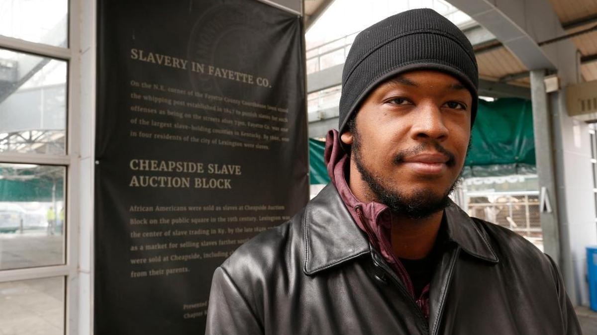 DeBraun Thomas, one of the co-founders of Take Back Cheapside, stood next to explanatory text in the Fifth Third Bank Pavilion at Cheapside Park in Lexington, Ky., Monday, December 18, 2017. Take Back Cheapside is a group that successfully helped persuade the city to move two Confederate-era statues this fall. The text tells about slavery in Fayette County. Cheapside was known as a large slave market before the Civil War.