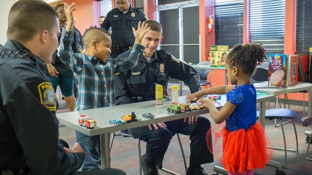 Officers Colin Meagher and Christopher Vaira played with Alexander Johnson, 6, and his sister Scarlett Johnson, 4. They were participating in an event to help police and people with autism get to know each other at the Village Branch of the Lexington Public Library on Saturday.