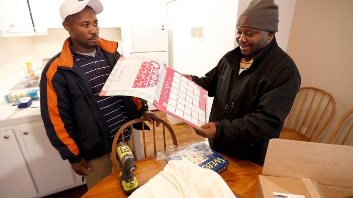 Asukulu Ramadhani and David Balondani, prepared to hang a calendar as they helped prepare an apartment in Lexington. St. Luke United Methodist Church has “adopted” a Congolese refugee family through Kentucky Refugee Ministries. The team, who all came here through KRM themselves, moved donated furniture into the family’s apartment to make it ready for their arrival. St. Luke United Methodist Church hosts a Swahili-speaking service that draws about 115 Congolese each week, and many of them are refugees.
