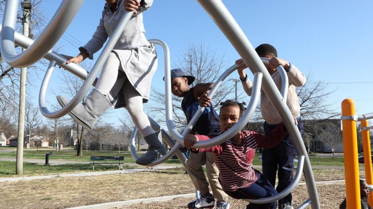 Jaziya Rice, 6, left, and Jay Rice III, 4, third from left, and others on the new playground at Douglass Park in Lexington.