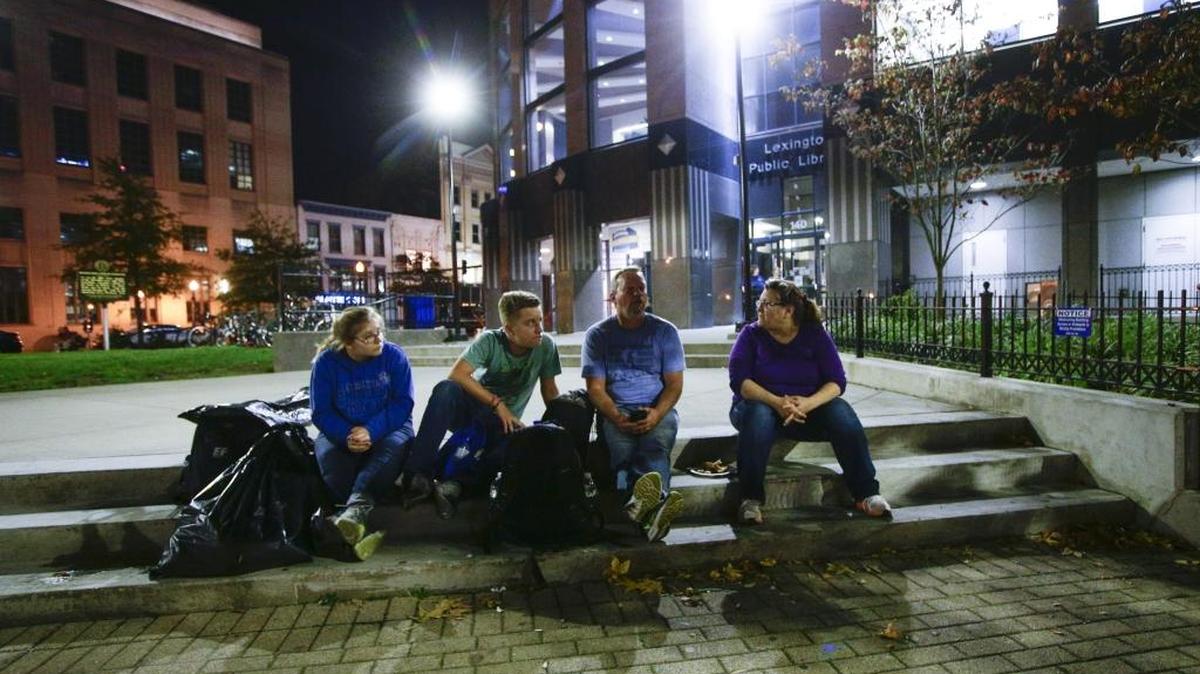 Dawn Brockman, left, Macy Brockman, 13, Ethan Thomas, 13, and Eric Thomas sat on the steps at Phoenix Park after eating dinner.