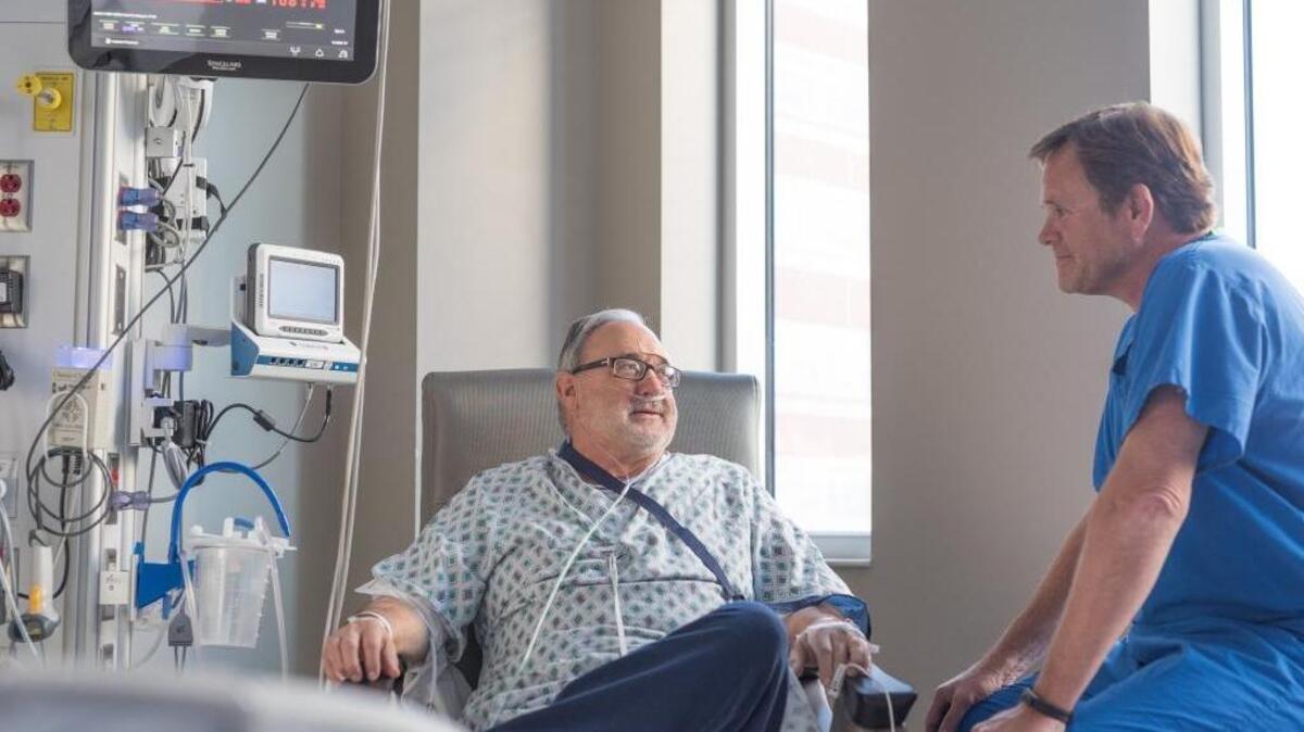 Dr. Hal Skinner visited with Paul McElwain, who went into cardiac arrest Monday night while playing a tennis match against Skinner, a cardiologist.