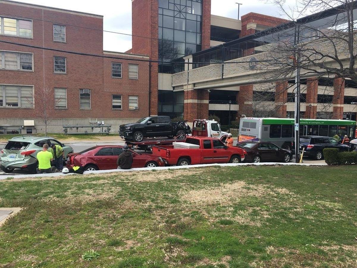 A tow truck prepared to haul one truck away after a Lextran bus crashed a line of parked cars by the University of Kentucky campus.