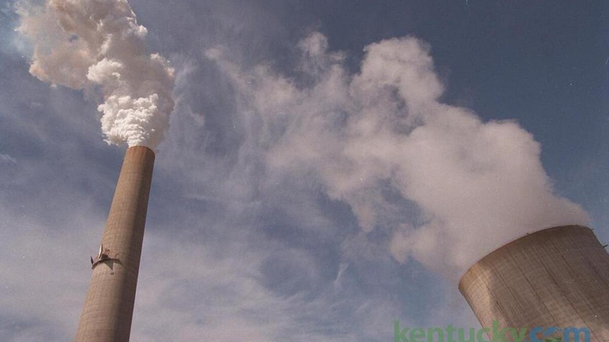 A power plant smoke stack, left, and cooling tower.