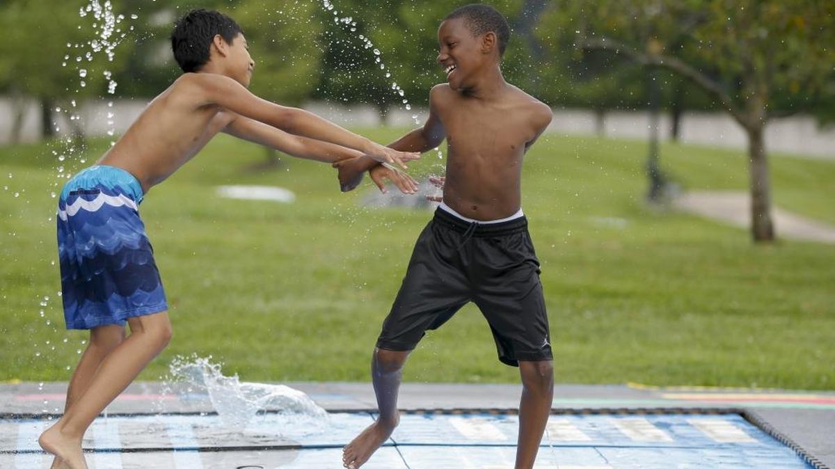 Cousins Micah Suarez, 10, left, and Vance Waide, 10, push each other and play at the SplashJAM park at Northeastern Park on Thursday, July 13, 2017 in Lexington, Ky.