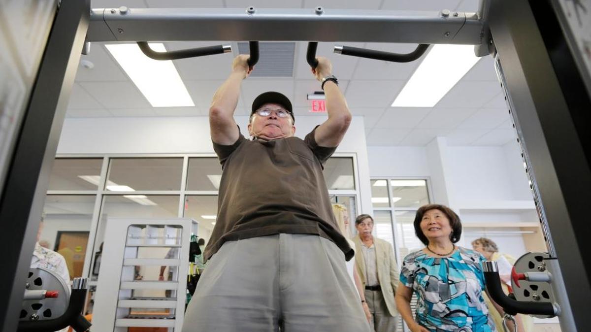 Senior Center member C.K. Chow did some pull-ups wih his wife, Lily Chow, right, looking on during a tour of the new Senior Center on Life Lane in Lexington in 2016.