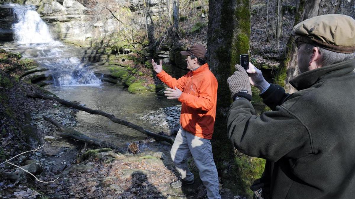 Burgess Carey, left, showed neighbor Bill Meade a natural waterfall feeding spring water into Boone Creek in 2011.