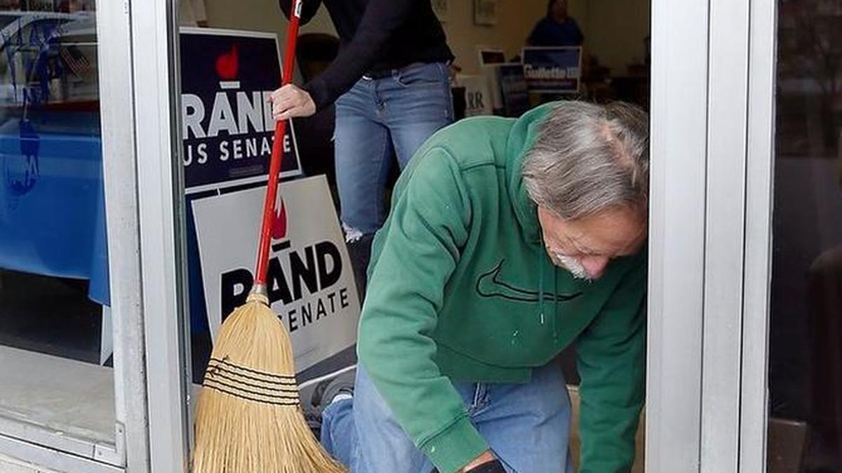David Allen and building owner Gina Johnson worked to clean up shattered glass at the Republican Party of Fayette County offices on Southland Drive. It appears someone used a small dumbbell to shatter the front door of the office, according to police.