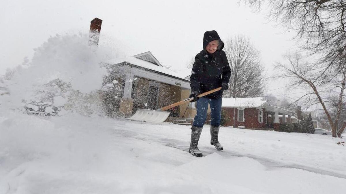 Veronica Walker shoveled snow from the driveway of her house join the 800 block of Melrose Ave. during a heavy morning snow in Lexington, Ky., Friday, January 22, 2016. Much of Kentucky is under a winter storm warning.