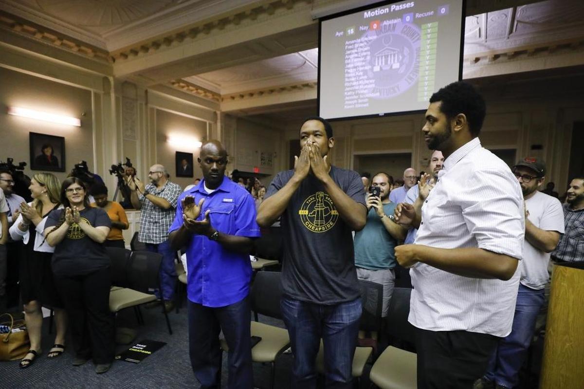 DeBraun Thomas, of Lexington, Ky., center, with the group Take Back Cheapside reacts after the Lexington-Fayette Urban County Council unanimously voted on a proposal to move two Confederate-era statues from downtown Lexington at the Lexington-Fayette Urban County Government Center in Lexington, Ky., Thursday, Aug. 17, 2017.
