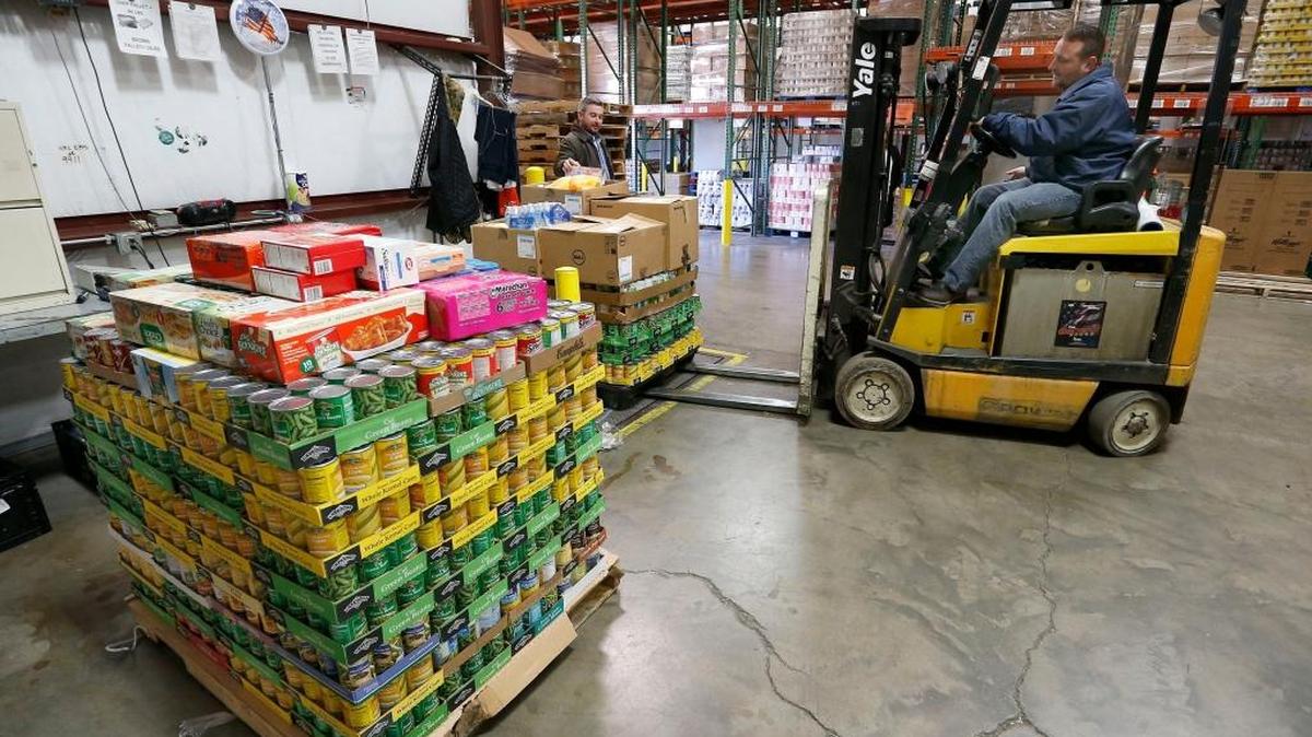 Kentucky Department of Agriculture Commissioner Ryan Quarles, middle, watched as God's Pantry warehouse manager Avery Long, right, moved pallets of donated food onto the scales at God's Pantry Food Bank 1685 Jaggie Fox Way in Lexington, Ky., Wednesday, December 28, 2016. Commissioner Ryan Quarles and Kentucky Department of Agriculture staff delivered over 3,232 pounds of foods donated by KDA employees during a department-wide food drive in December. The food drive was an extension of the Hunger Initiative that Commissioner Quarles launched in June to look for ways to reduce food insecurity in Kentucky.