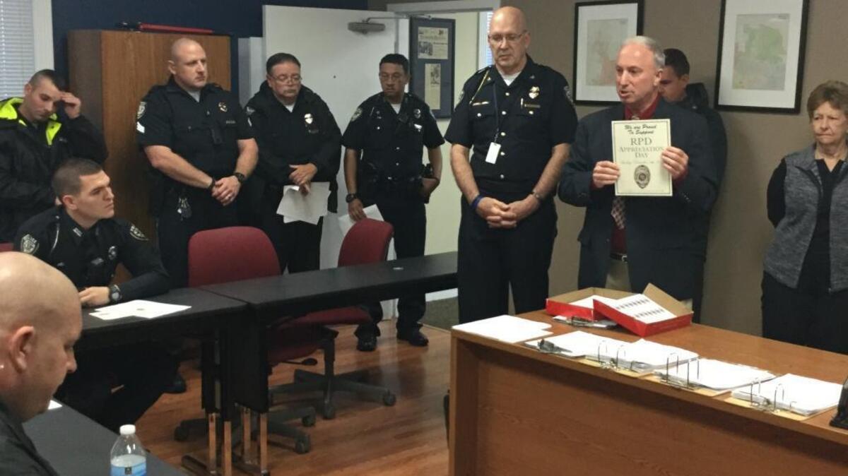 Richmond resident Steve Rosenberg, at right holding paper in his hands, spoke to police officers assembled in the Richmond department’s roll-call room. Richmond Police Chief Larry Brock stands at Rosenberg’s right.