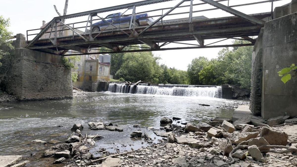 A truck crossed the Weisenberger Mill Bridge near Midway, on May 30, 2014. The state has made the bridge available for relocation since it plans to build a new bridge at the site. The bridge has been standing since the 1930s and has shown noticeable wear and tear as a result. The Weisenberger Mill is in the background.