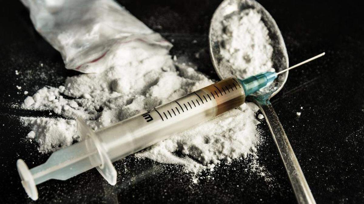 Drug syringe and cooked heroin on spoon.