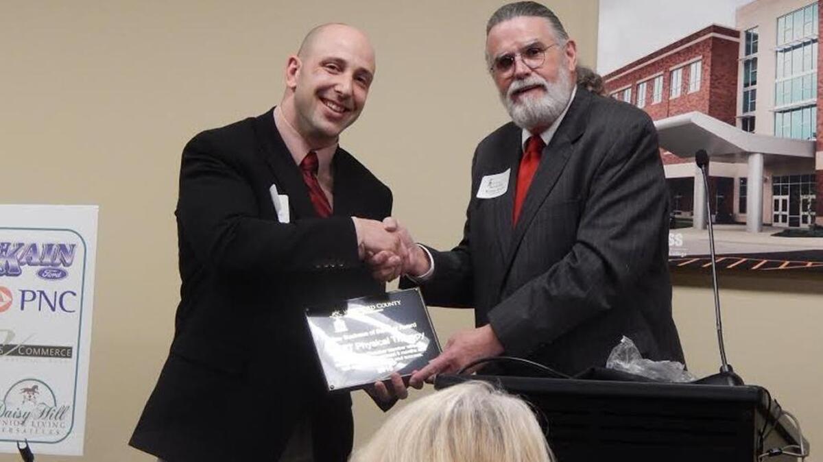 Dr. James Escaloni, KORT Physical Therapy’s clinic director, left, accepted the New Business of the Year Award from Kenny Smith, owner of Midway’s Kennydid Gallery and chairman of the Woodford County Chamber of Commerce.