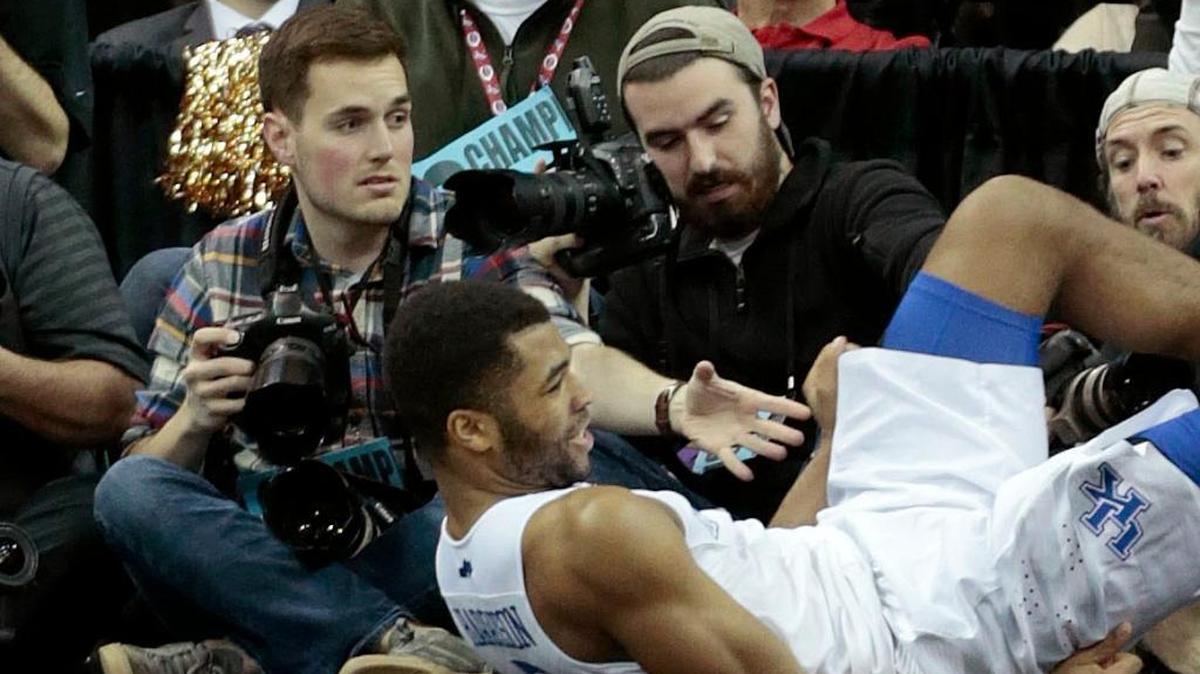 Student journalist Jonathan Krueger, left, was shooting photos at the University of Kentucky game in March 2015 when Andrew Harrison landed in a row of photographers.
